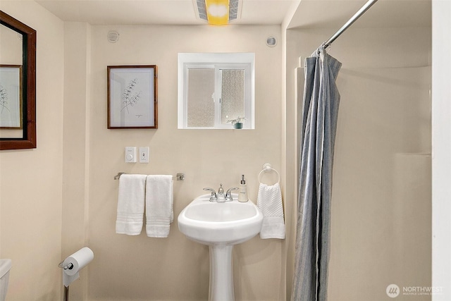 full bath featuring a shower with shower curtain, toilet, and visible vents