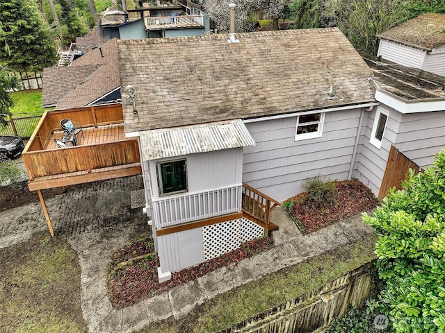 exterior space with roof with shingles and a deck