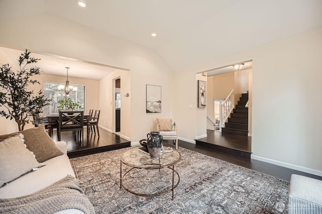 living room featuring wood finished floors, an inviting chandelier, baseboards, stairs, and vaulted ceiling