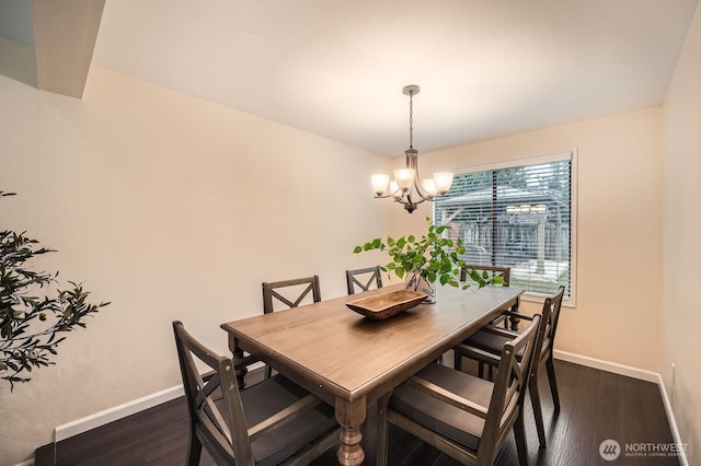 dining room featuring a chandelier, baseboards, and dark wood-style floors