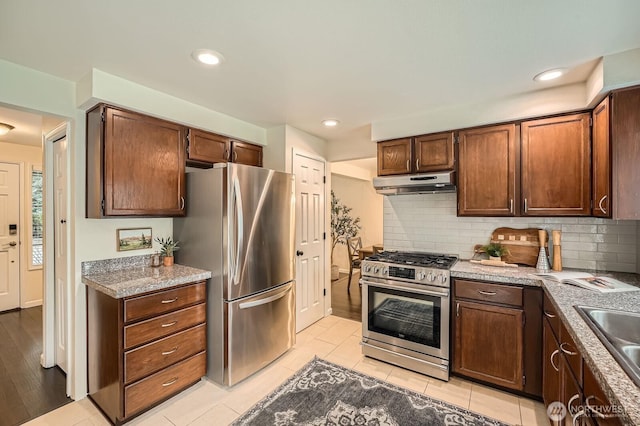 kitchen with under cabinet range hood, tasteful backsplash, appliances with stainless steel finishes, and recessed lighting