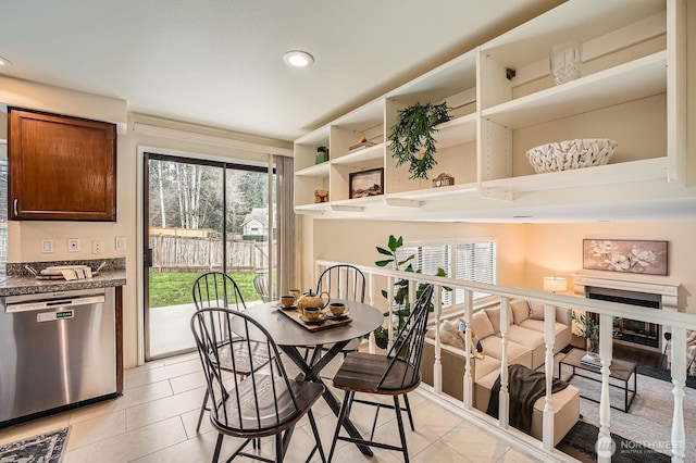 dining room with light tile patterned floors, a fireplace, and recessed lighting