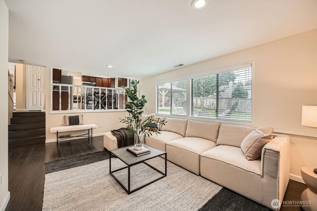 living area with recessed lighting, visible vents, wood finished floors, and stairs