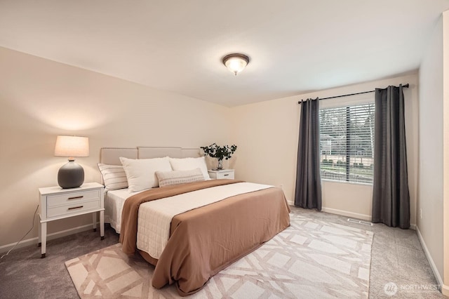 bedroom with baseboards and light carpet