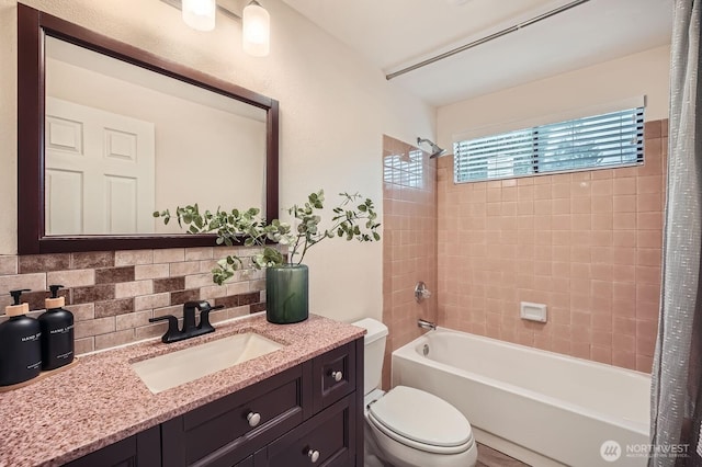 full bath featuring vanity, toilet, shower / bath combo with shower curtain, and backsplash