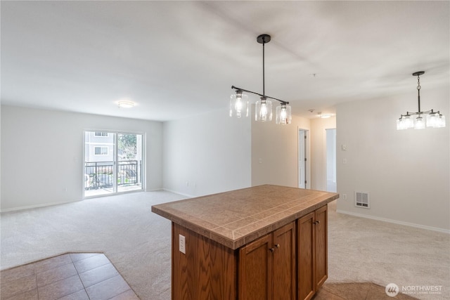 kitchen featuring open floor plan, visible vents, light colored carpet, and brown cabinets