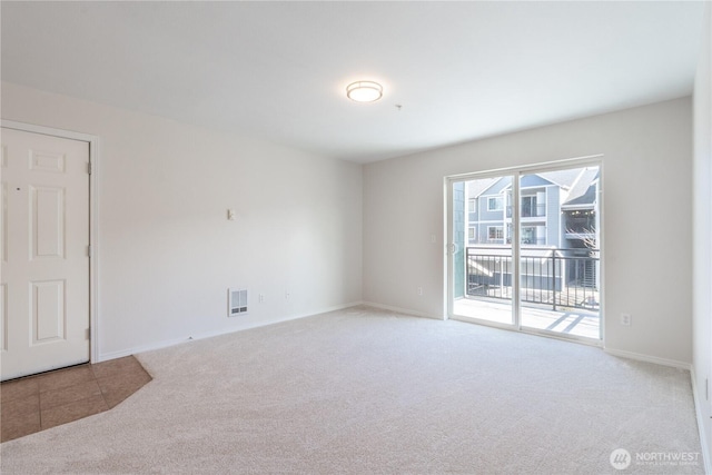 carpeted spare room with baseboards and visible vents