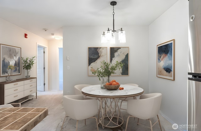 dining room featuring baseboards and a chandelier