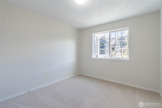 unfurnished room with light colored carpet and baseboards