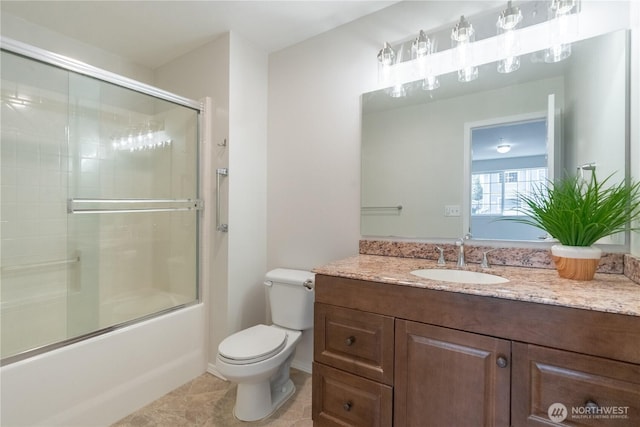 full bath featuring combined bath / shower with glass door, toilet, vanity, and tile patterned flooring