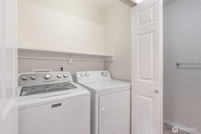 laundry area featuring baseboards, separate washer and dryer, and laundry area