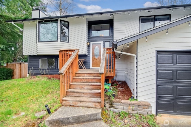 exterior space featuring a front lawn, a garage, and fence