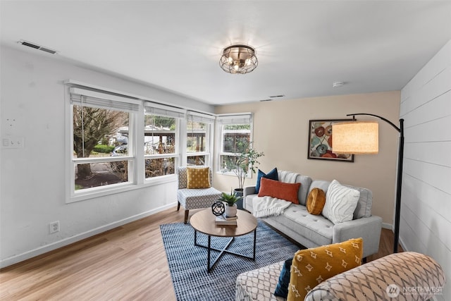 living area with light wood-type flooring, baseboards, and visible vents