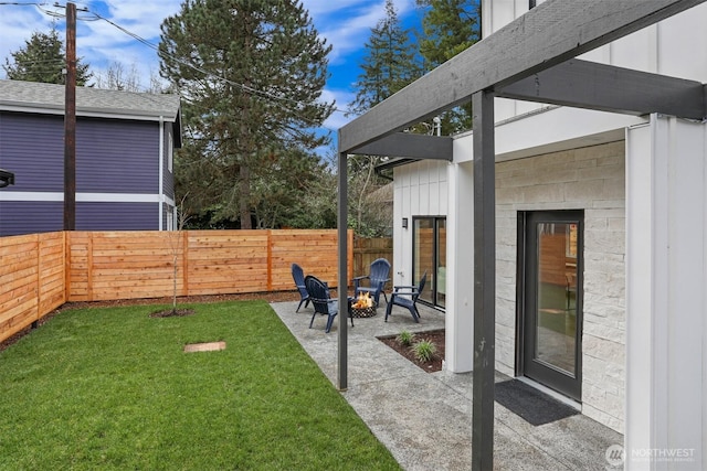 view of yard with a patio, a fenced backyard, and an outdoor fire pit