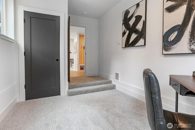 carpeted office space with visible vents and baseboards