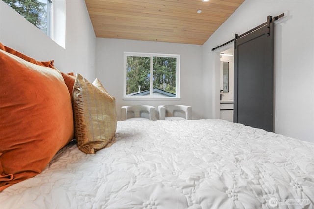 bedroom featuring a barn door, multiple windows, wood ceiling, and vaulted ceiling