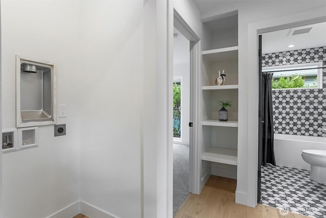 full bathroom featuring built in features, wood finished floors, visible vents, shower / bath combo, and toilet