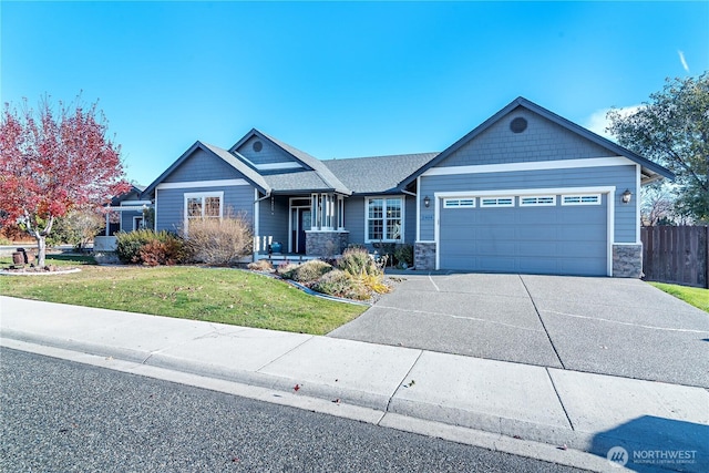 craftsman house featuring driveway, stone siding, fence, a front yard, and a garage