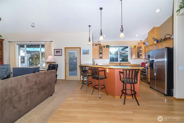 kitchen featuring a wealth of natural light, open floor plan, appliances with stainless steel finishes, and a peninsula