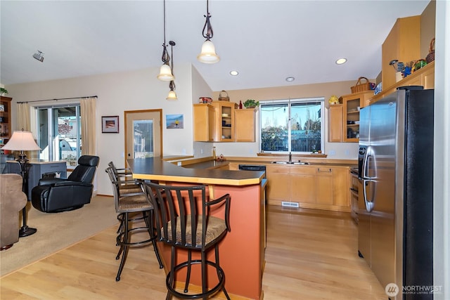 kitchen featuring a sink, stainless steel appliances, glass insert cabinets, and a peninsula