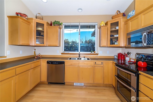 kitchen with visible vents, appliances with stainless steel finishes, light wood-style floors, and a sink