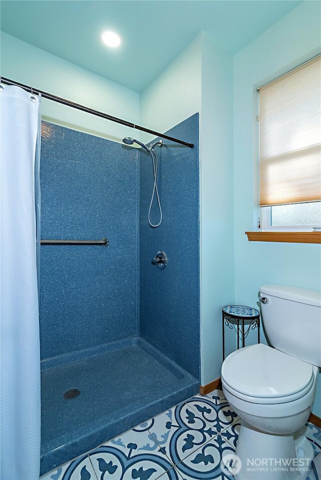 bathroom featuring curtained shower, toilet, and tile patterned flooring