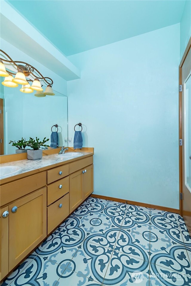 bathroom featuring a sink, baseboards, double vanity, and tile patterned flooring