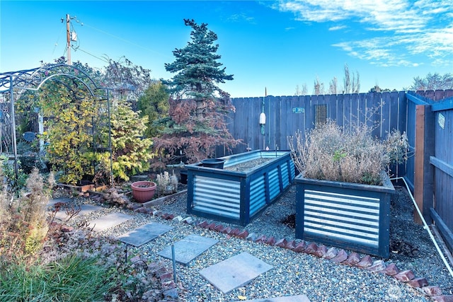 view of patio / terrace with a vegetable garden and fence