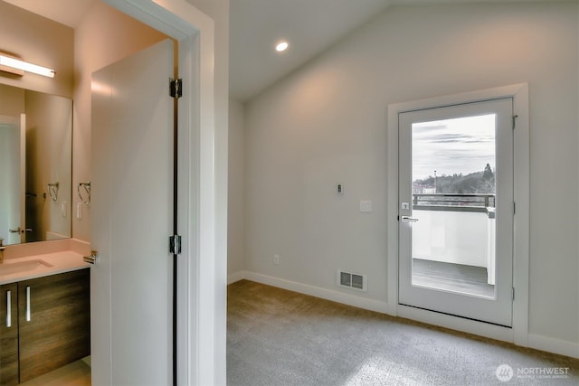 doorway to outside with baseboards, visible vents, a sink, vaulted ceiling, and carpet flooring