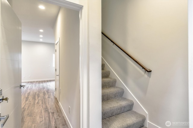 staircase with recessed lighting, wood finished floors, and baseboards