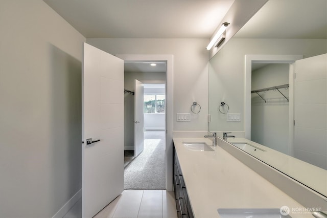 bathroom featuring double vanity, baseboards, and a sink