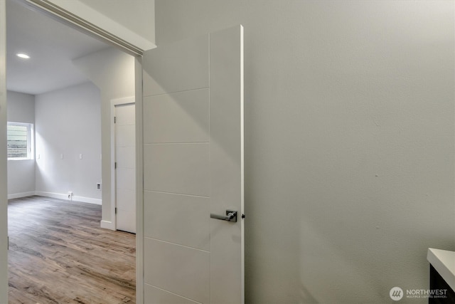 interior space featuring recessed lighting, baseboards, and wood finished floors