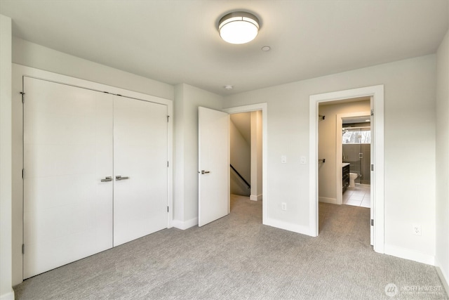 unfurnished bedroom featuring a closet, baseboards, and carpet floors