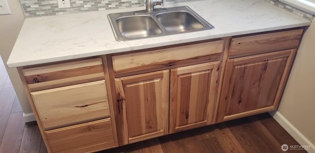 kitchen featuring dark wood finished floors, light countertops, decorative backsplash, brown cabinets, and a sink