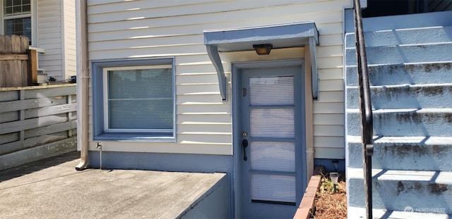 doorway to property featuring fence