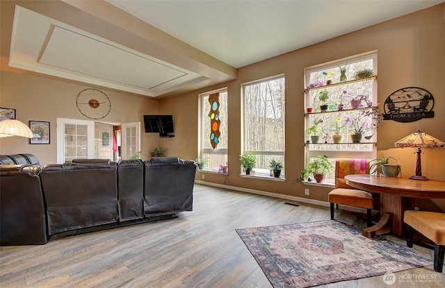 living room featuring visible vents, baseboards, and wood finished floors