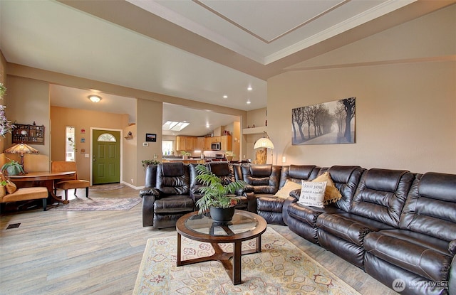 living area featuring recessed lighting, baseboards, vaulted ceiling, and light wood finished floors