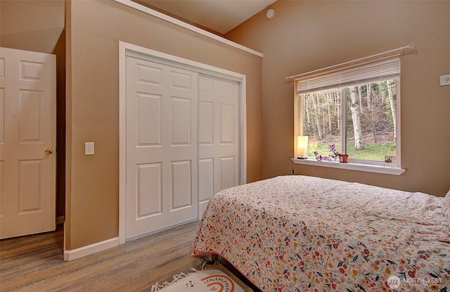 bedroom featuring a closet, baseboards, and wood finished floors