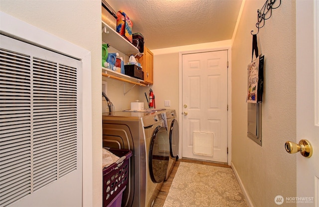 laundry room with washer and clothes dryer, a textured ceiling, baseboards, a heating unit, and laundry area