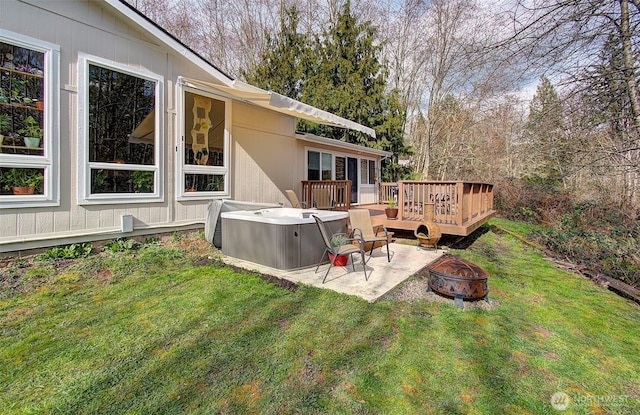 view of yard with a patio, a wooden deck, a hot tub, and an outdoor fire pit