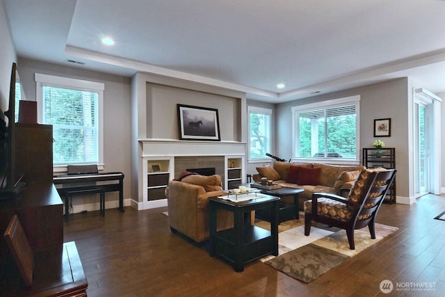 living room featuring recessed lighting, a fireplace, baseboards, and wood finished floors