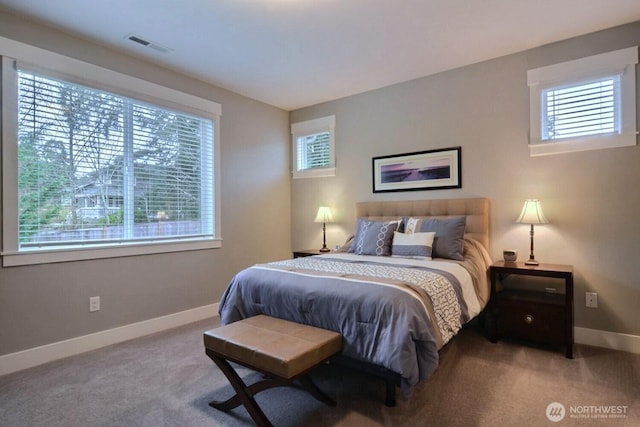 carpeted bedroom featuring visible vents, multiple windows, and baseboards