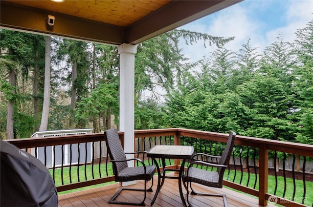 wooden terrace with grilling area and outdoor dining area