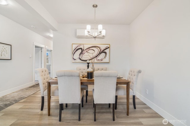 dining area featuring wood finished floors, baseboards, and a chandelier