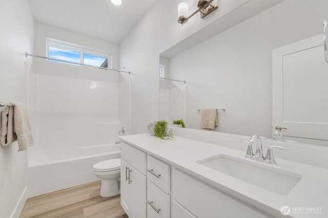 bathroom with bathtub / shower combination, toilet, wood finished floors, and vanity