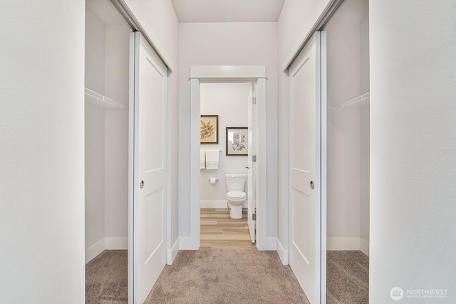 corridor with light colored carpet and baseboards