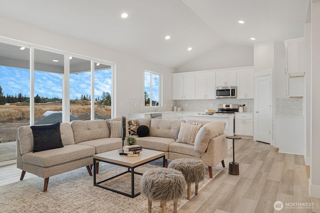 living room with recessed lighting, high vaulted ceiling, and light wood-type flooring