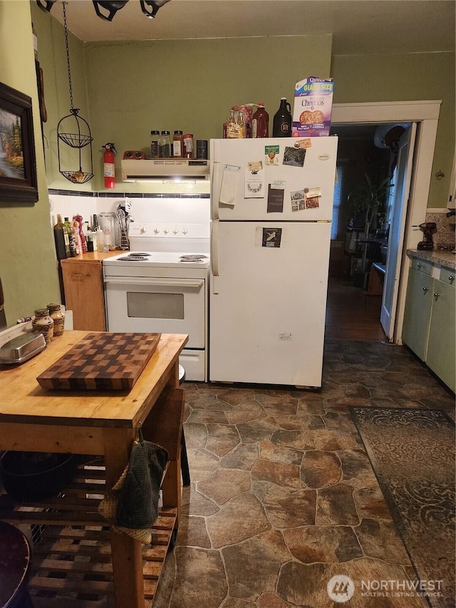 kitchen with under cabinet range hood, stone finish flooring, white appliances, and butcher block countertops