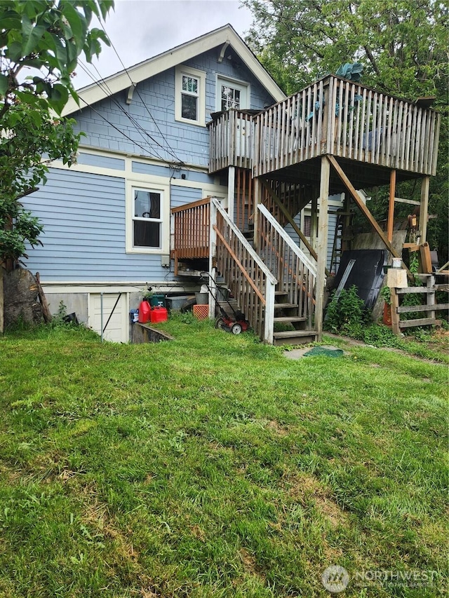 rear view of house featuring stairway, a yard, and a deck