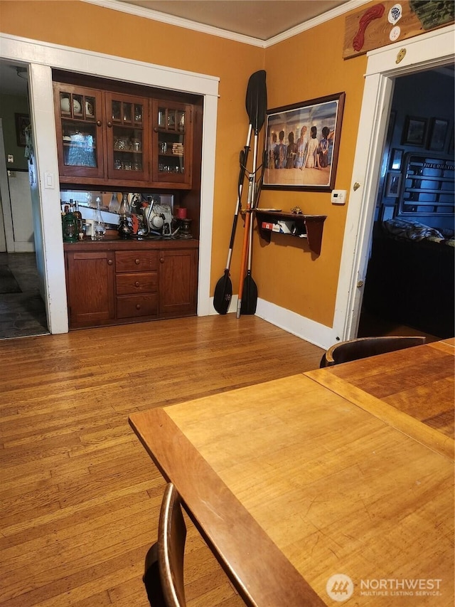 interior space featuring light wood finished floors, baseboards, and ornamental molding